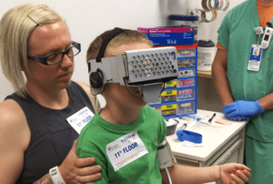 A pediatric patient wears a lightweight, cardboard headset. Games are loaded onto a smartphone. Then the child is immersed in the world of an interactive display that takes their mind off the needle prick.