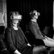 two people using virtual reality goggle sitting down