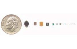 Miniature device components next to a dime coin for scale