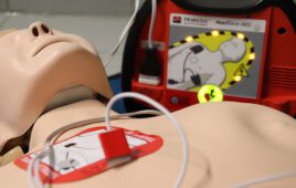 An automated external defibrillator (AED) on a medical demonstration dummy