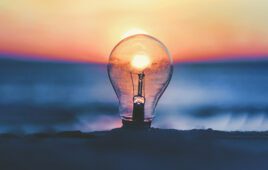 Unsplash image of a lightbulb on a beach with the sun rising behind it to symbolize the medtech innovation of medical device startups