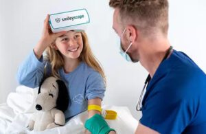 A child wears SmileyScope virtual reality goggles during a medical procedure.