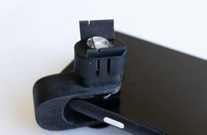 A plastic device that clips onto a smartphone to take blood pressure readings using the camera and flash.