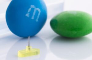 Imcomet's M-Duo device next to M&M candy for scale.