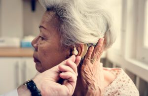 An elderly woman with a hearing aid.