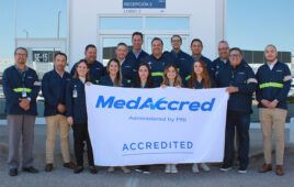 A photo of Jabil Mexico employees holding a MedAccred banner in front of their PCBA facility.