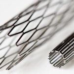 One result of medical nitinol processing is a stent; pictured are two stents made of medical-grade nitinol, one compressed and the other expanded.