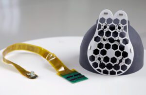 A photo of the wearable ultrasound system, including an ultrasound sensor and the 3D printed device for attaching the sensor to the bra.